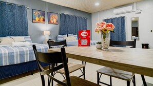 A hotel room with two beds, a dining table, chairs, a vase with flowers, and a sign indicating a free Wi-Fi zone. - Hotel Five Stars sv (Berlin)