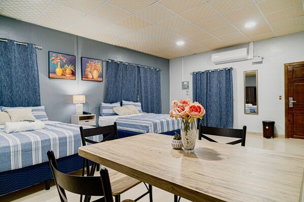 A hotel room with two single beds, a wooden dining table, and a vase of flowers. - Hotel Five Stars sv (Berlin)