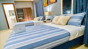 A hotel room with a large bed, a laptop on the bed, a nightstand with a lamp, and a bathroom visible in the background. - Hotel Five Stars sv (Berlin)