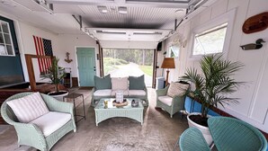 Un interior acogedor con mobiliario de mimbre, una mesa de centro y vistas al exterior.
