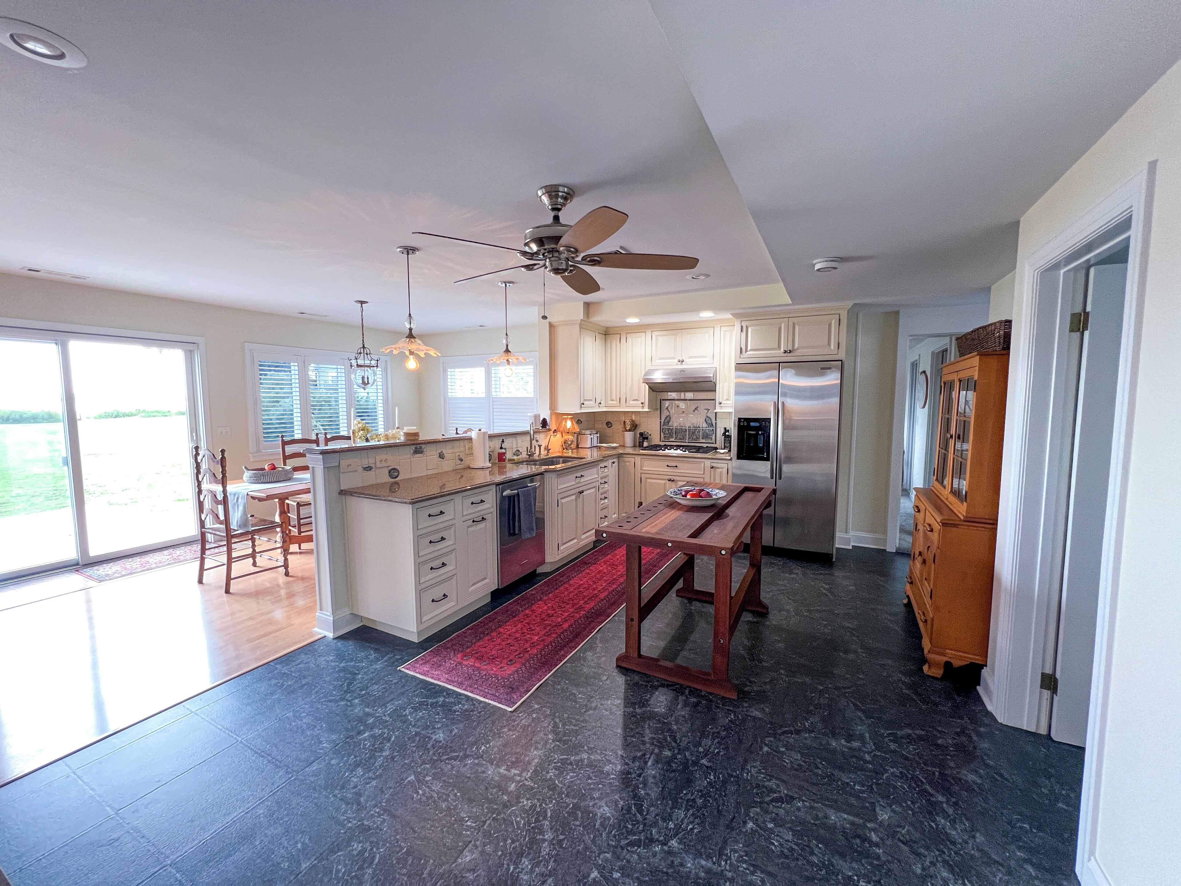 A spacious kitchen with a central island, a built-in oven, and a refrigerator.