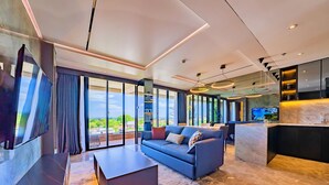 A modern living room with a sofa, coffee table, and a TV. - The One Umalas (Kerobokan)