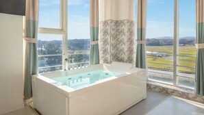 A modern bathroom with a large bathtub, a window with a view of a landscape, and curtains. - Gangneung Meerbrick Spa Pension (Gangneung)