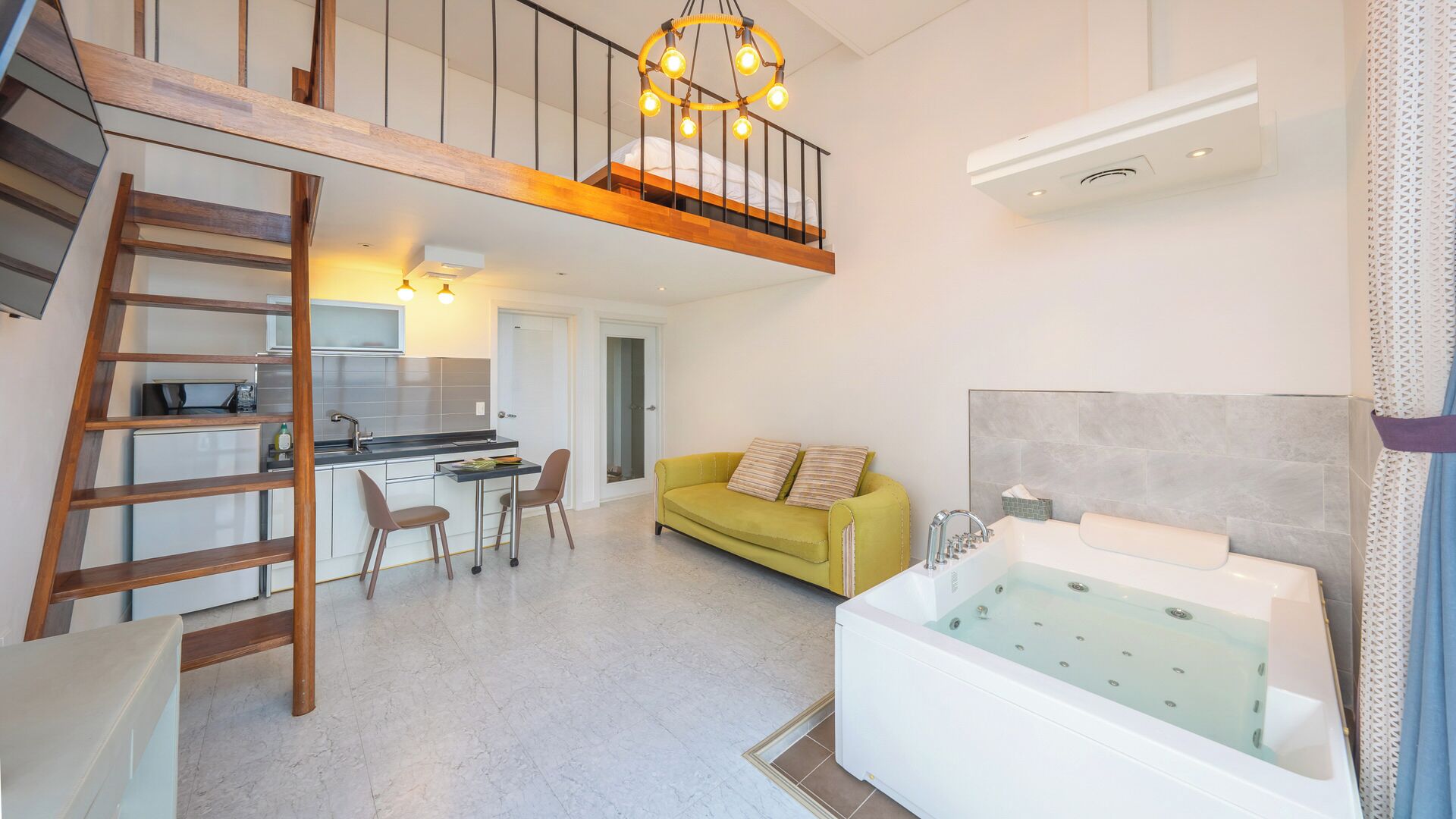 A modern apartment with a loft bedroom, a kitchen, a dining area, a living room, and a bathroom.