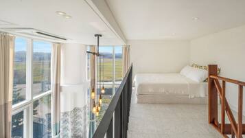 Un dormitorio con un ventanal grande, una cama y vistas al campo.