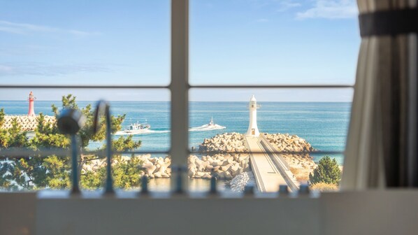 A view of a coastal area with lighthouses and a boat on the water.