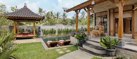 Ein Innenhof mit Pool, einem Holz-Pavillon und einer Sitzgelegenheit im Freien.