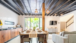 Een moderne keuken met houten keukenkastjes, een eettafel en een groot raam.