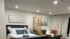 Een moderne slaapkamer met een bed, een stoel, een bank en een bureau.