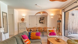 A modern living room with a sofa, coffee table, and dining area.