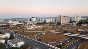 A cityscape with modern buildings, a highway interchange, and a large open area with minimal vegetation.