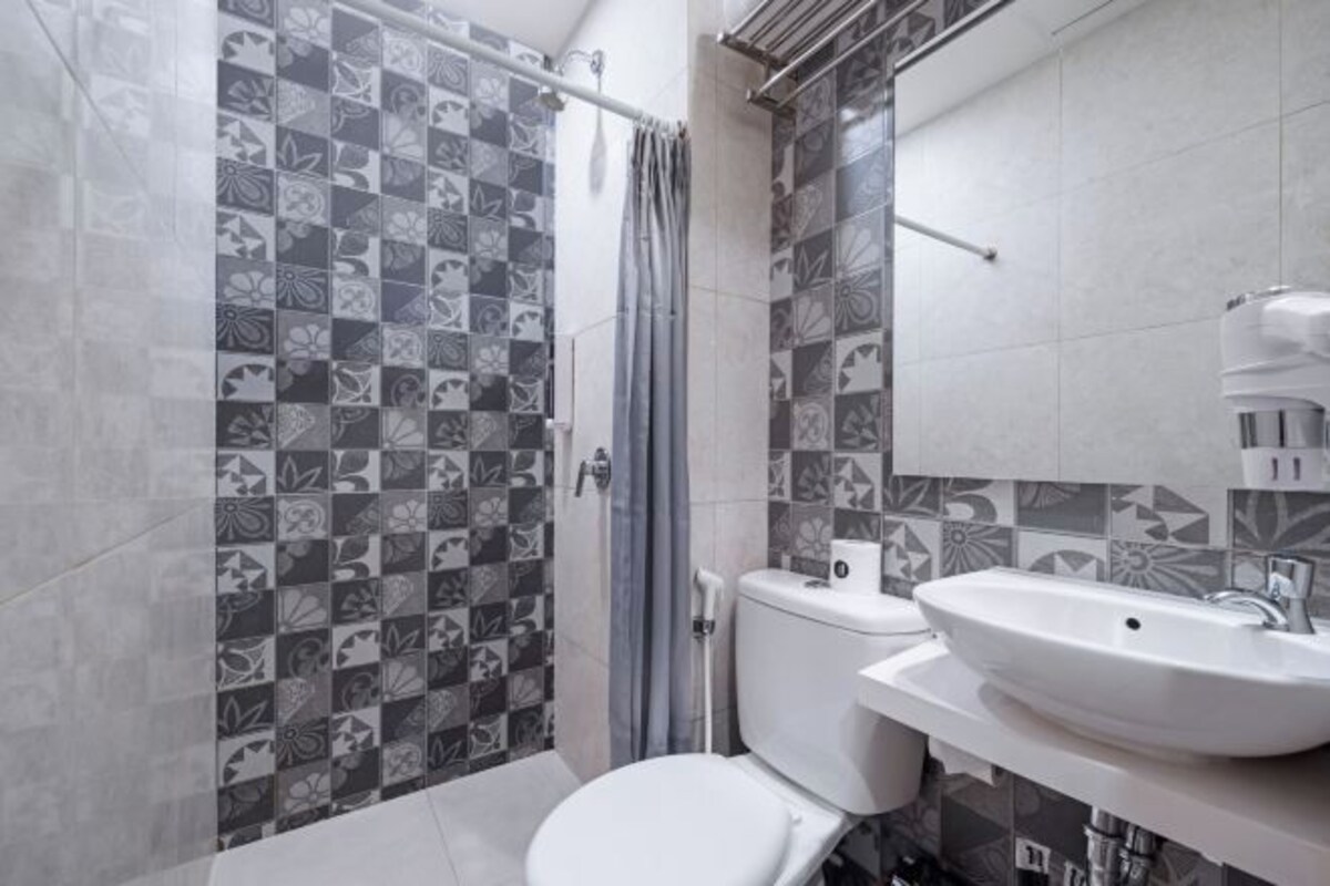 A bathroom with a toilet, sink, and shower area.