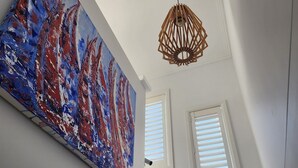 Een trap met witte muren, een houten leuning en een plafondlamp.