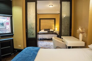 Una habitación de hotel con una cama, un escritorio, una silla y una ventana.