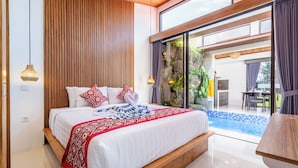 A modern bedroom with a large bed, wooden headboard, and a view of a swimming pool. - Eden Villas Ubud (Ubud)