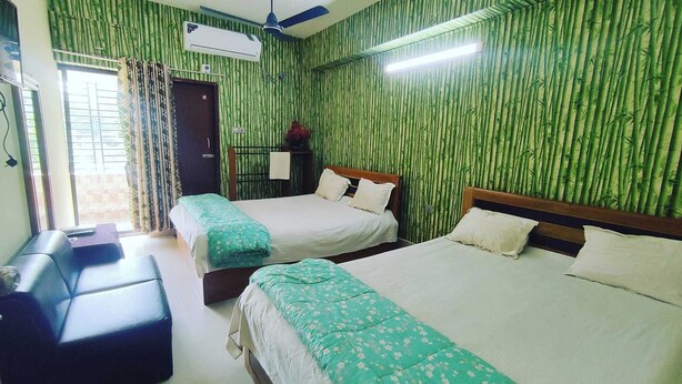 A hotel room with two beds, a desk, and a window with curtains.