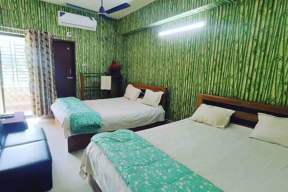 A hotel room with two beds, a desk, and a window with curtains.
