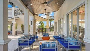 An outdoor seating area with blue cushioned chairs and a central orange bowl.