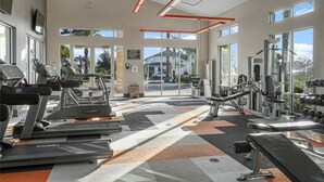 A gym with treadmills, weight machines, and dumbbells.