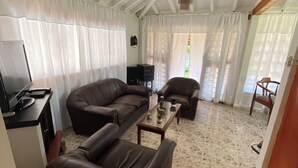 A spacious living area with a high ceiling, a sofa, a coffee table, and a television. - VILLA LIGIA IN MEDELLIN (Medellín)