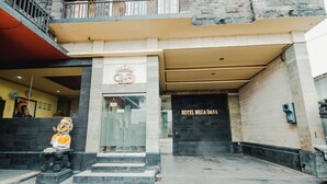 The entrance to Hotel Mega Dana with a prominent sign and a statue in front. - Hotel Mega Dana (Denpasar)