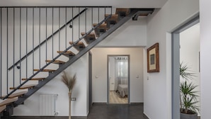 A modern interior with a staircase, a radiator, a potted plant, and a framed picture on the wall. - 4 BDR Villa Filleona with Pool, Labin, Croatia (Labin)