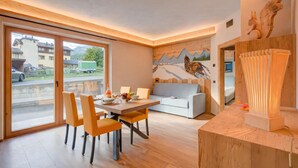 A modern interior with a dining area, sofa, and a mural. - Arnica Ski In 10 m, Livigno, Italy (Livigno)