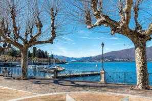 A lakeside park with a dock, benches, and a lamppost. - Casa Antonia: Lake Maggiore Villa with Private pool, Porto Valtravaglia, Italy (Porto Valtravaglia)