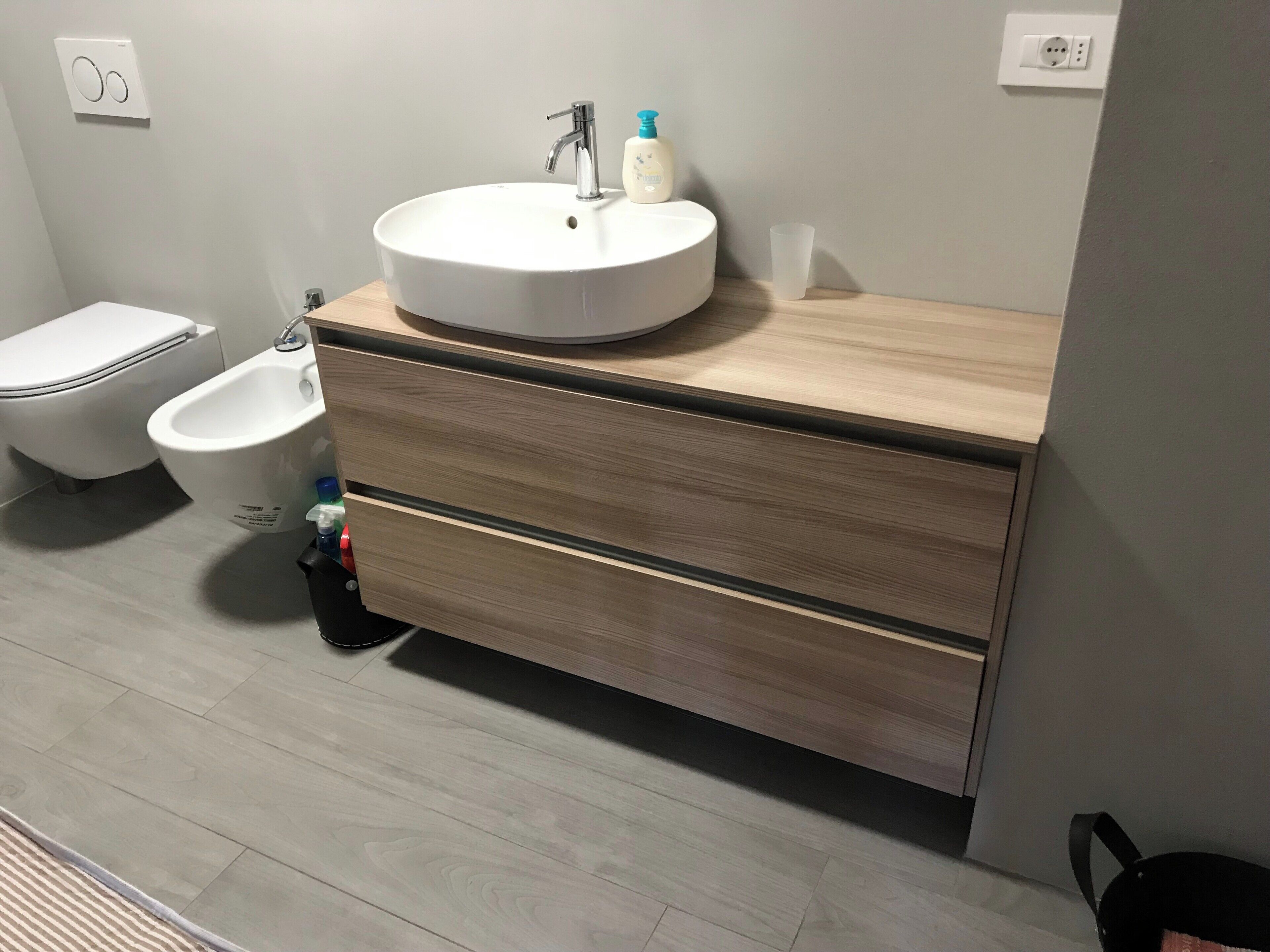 Un bagno con un lavandino bianco, un bidet e un water.