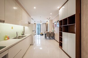 Una cocina moderna con comedor, que incluye una encimera amplia, electrodomésticos de acero inoxidable y una araña.