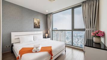 A modern hotel room with a large bed, a city view, and a window with curtains.