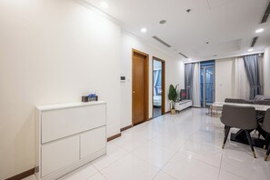 Una sala de estar moderna con una consola blanca, un sofá y un comedor con mesa y sillas.