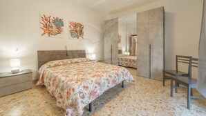 Ein Schlafzimmer mit Bett, Nachttisch, Stuhl und Kleiderschrank.