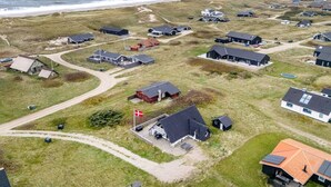 An aerial view of a coastal residential area with houses, a flag, and a beach. - "Kaja" - 150m from the sea by Interhome (Harboøre)