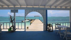 A covered pier leading to a boat dock with a sign reading "Tour to the Cave". - Exuma Beach Point (Rolleville)
