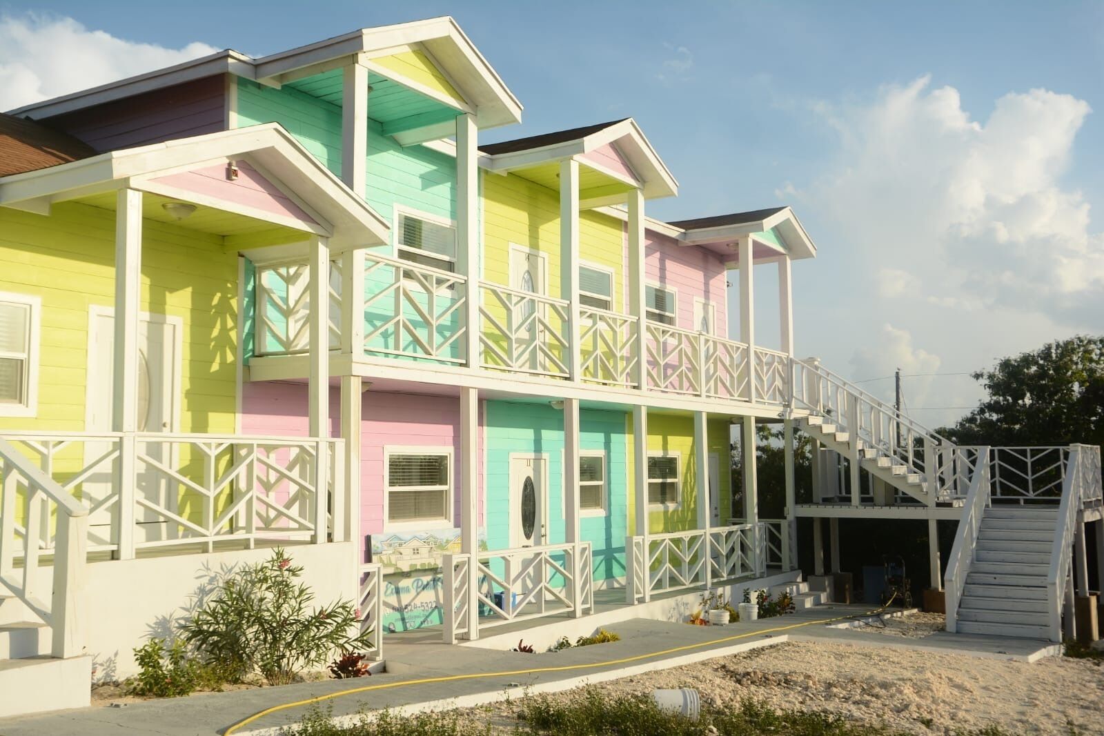 A multi-story building with balconies and a staircase leading to a dock.