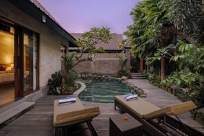 A pool area with lounge chairs and a wooden deck. - Monique Ubud Villa (Ubud)