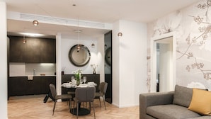 Een moderne woonkamer met een bank en een eethoek met een tafel en stoelen.