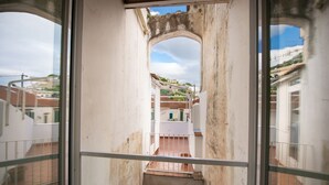Vista des d'un balcó amb una arcada de pedra que condueix a un nivell inferior.