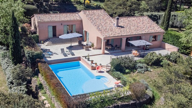 Ein zweistöckiges Haus mit Swimmingpool, Außenbereich und Garten.