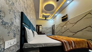 Camera da letto moderna con un letto grande, una testiera con un dettaglio blu, una parete con motivo marmorizzato e un soffitto con illuminazione a incasso.