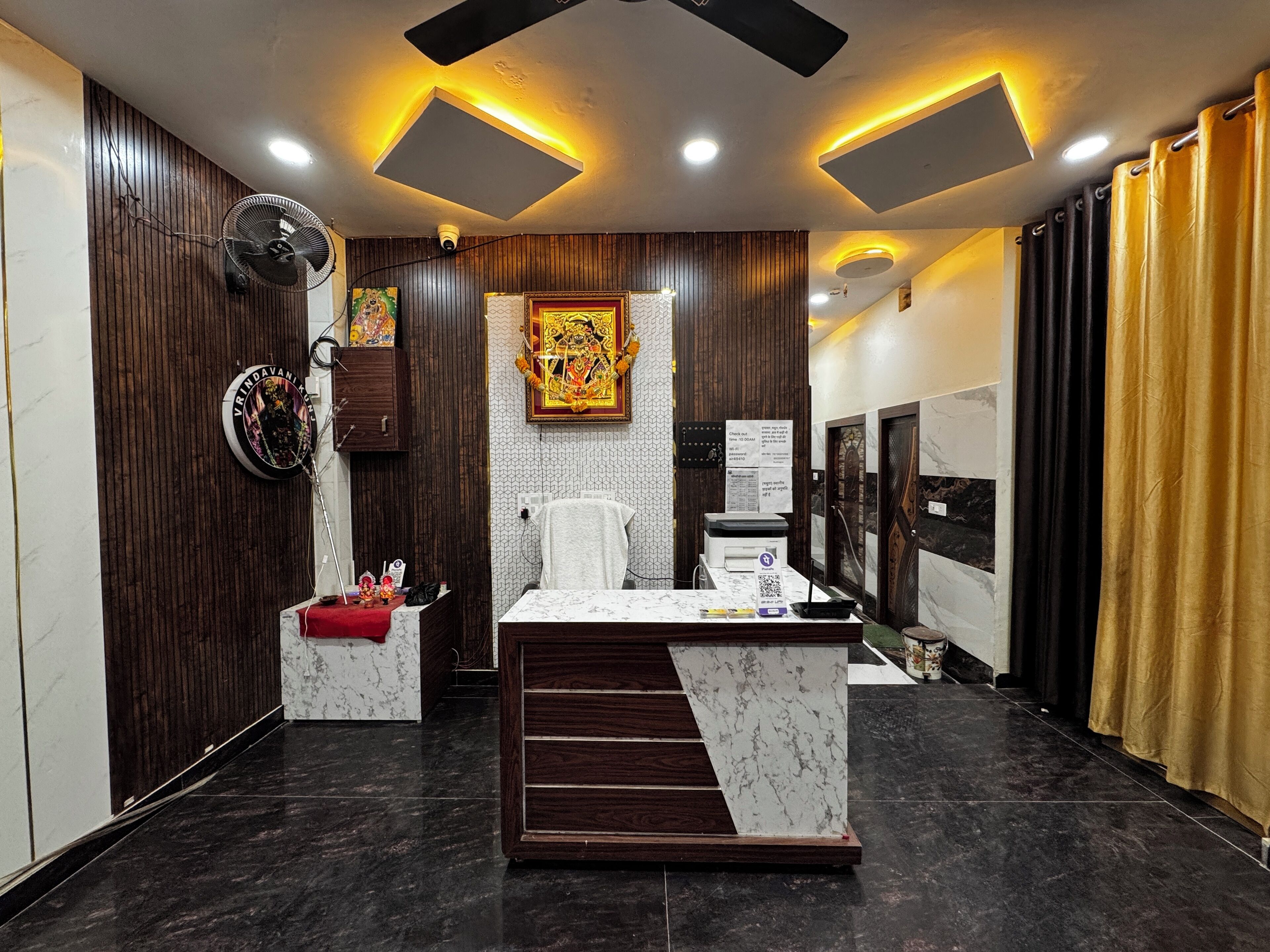 A modern office with a reception desk, wooden paneling, a decorative wall piece, and a check-in counter.
