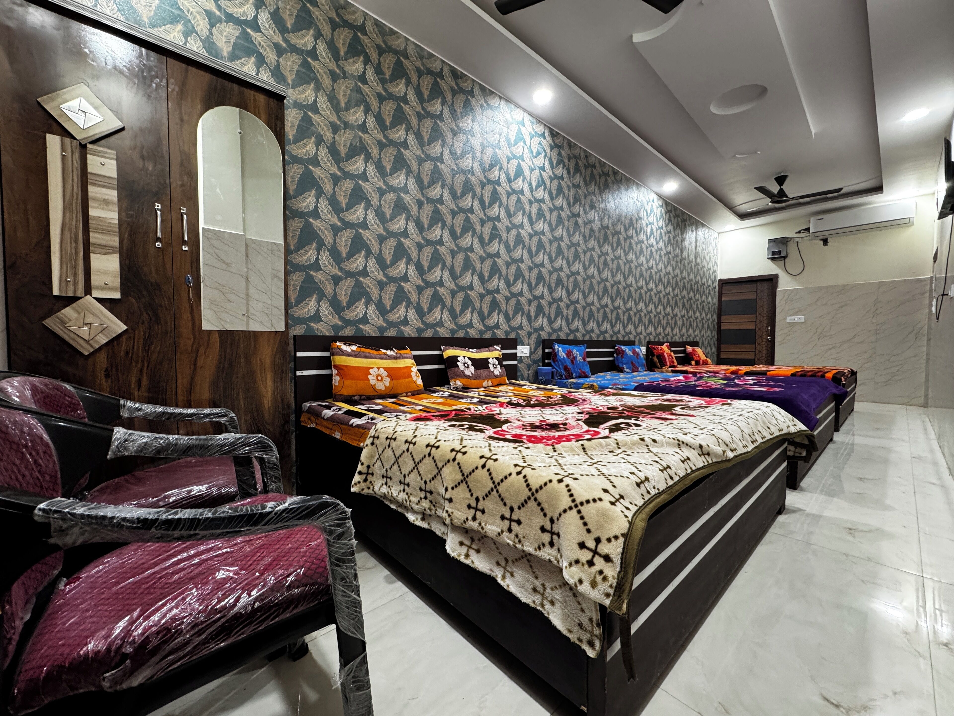 A bedroom with a bed, a wardrobe, a mirror, and a ceiling fan.