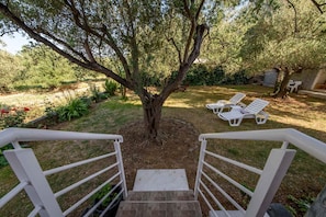 A staircase leading to a garden with a tree, white chairs, and a stone wall. - Apartments in Kozino/zadar Riviera 7951 (Zadar)