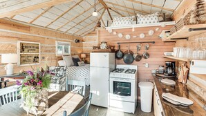 Een knus chaletinterieur met een eethoek, keuken en een slaapverdieping.
