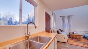 A modern kitchen with a large window, a sink, and a wooden countertop. - Kenai River Retreat ~ 4 Mi to Morgan's Landing! (Sterling)