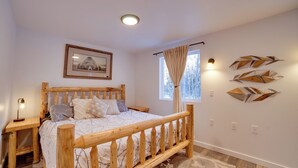 A bedroom with a wooden bed, a nightstand, a framed picture on the wall, and decorative wall art. - Kenai River Retreat ~ 4 Mi to Morgan's Landing! (Sterling)