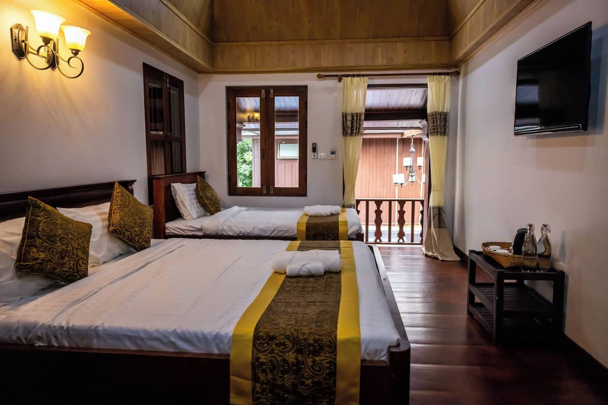 Une chambre d’hôtel avec deux lits, une télévision, un plafond en bois et une vue sur l’extérieur.