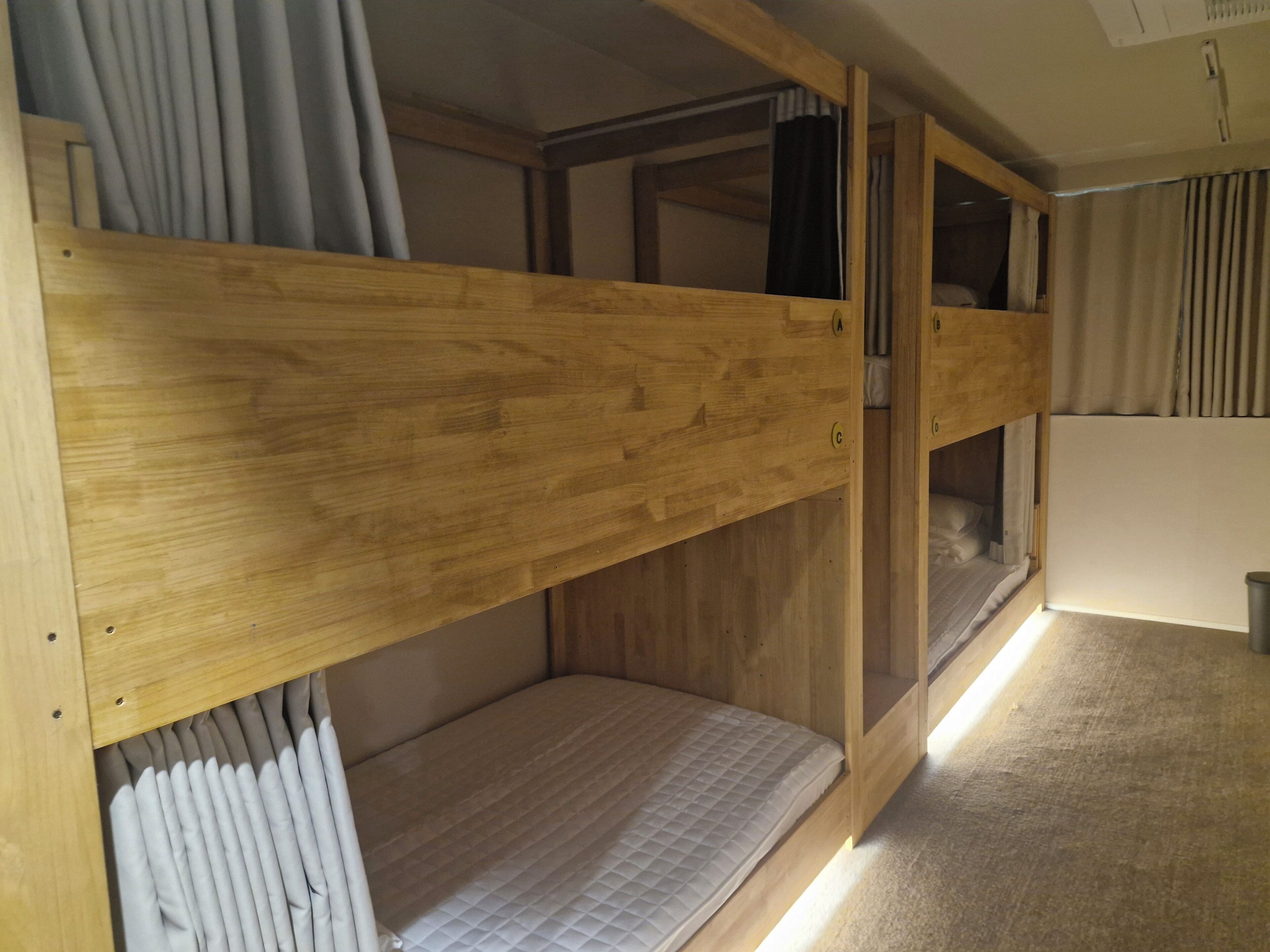 A bunk bed room with wooden frames and a mattress.