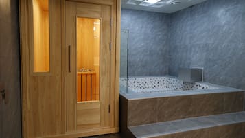 Een aparte badkuip en douche, een diep bad, een regendouche, handdoeken